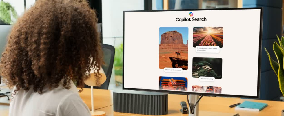 Person sitzt an Schreibtisch vor Bildschirm, darauf die Copilot Search in Bing